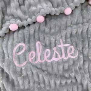 Cobija gris con pompones rosados