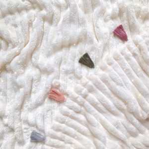 Cobija beige con flecos tonos tierra