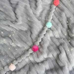 Cobija gris con pompones de colores